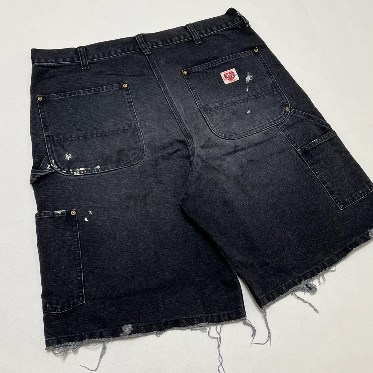 SAINT Mxxxxxx DOUBLE KNEE SHORTS/BLK Knee patches splashed with ink, washed and damaged denim shorts. Washed black S-XL. Custom woven and dyed denim denim with clear texture. Rewashed and faded to create local mottled fading/hole effects. Artificial distressing to simulate natural traces of wear. Original consistent damage treatment. Hand splashed ink and paint. Original consistent wash mark/pocket mark. Double knee patch. Rivet reinforcement. Improve functionality and enhance design.